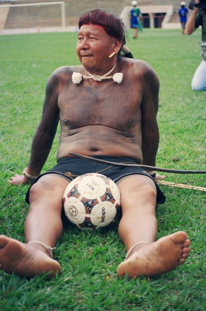 Índio sentado com bola de futebol