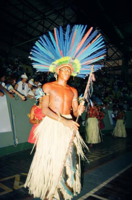 Indígena com cocar e lança em ritual