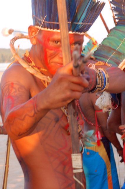 Índio posando para foto com arco e flecha armados