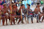 Vários índios sentados com arcos e flechas