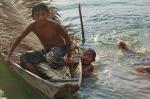 Meninos índios em canoa e rio