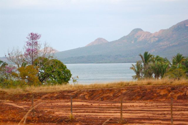 Estrada,  com rio e montanhas ao fundo