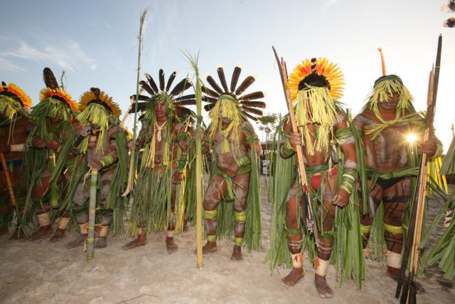 índios com adereços típicos posando para foto