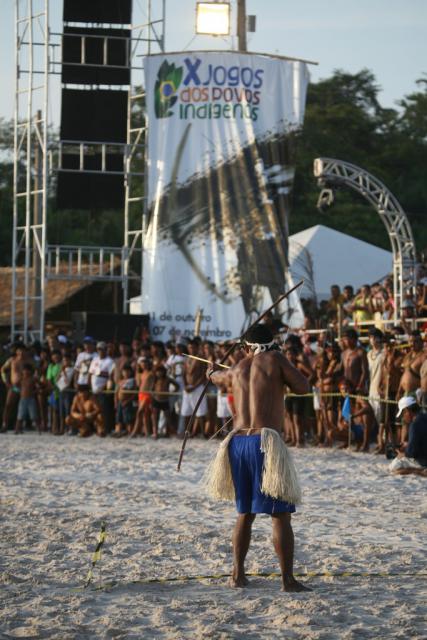 índio com adereços típicos e arco e flecha