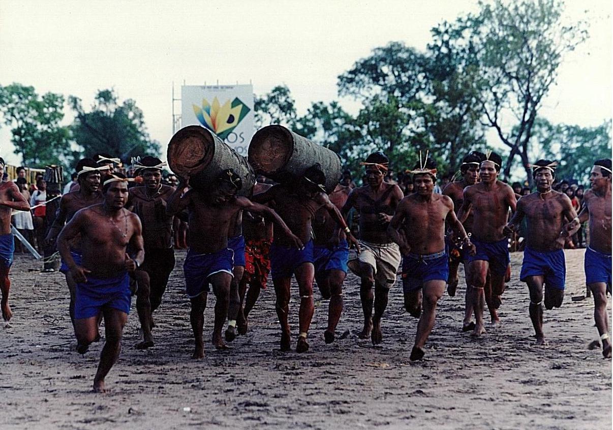 Índios em corrida com tora