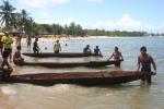 índios preparando canoas para competição