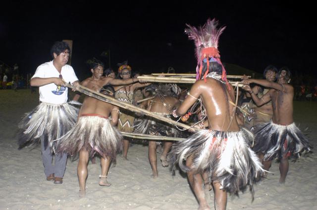 índios em ritual com pedaços de madeira