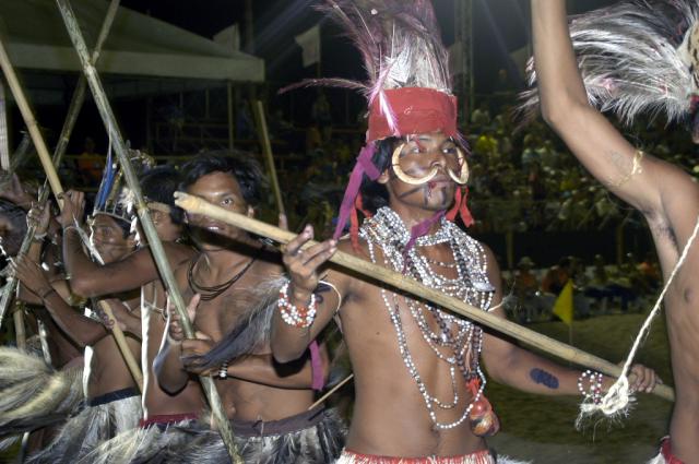 índios em ritual com pedaços de madeira