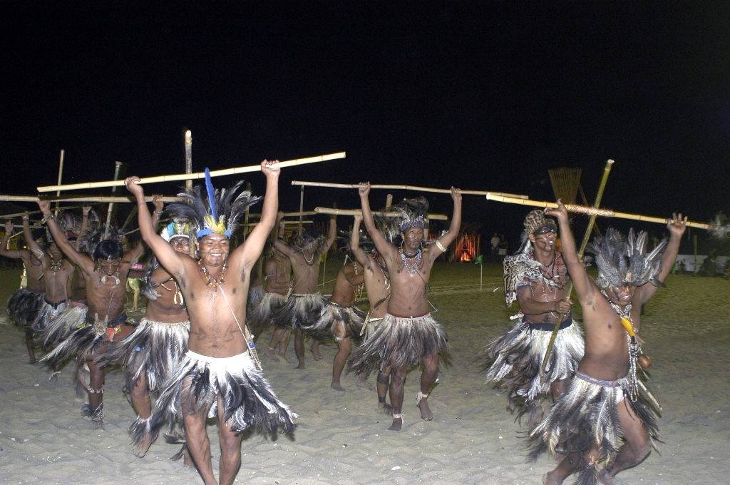 índios em ritual com pedaços de madeira