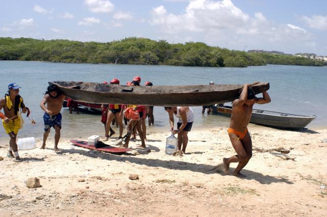 índios carregando canoa