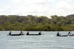 índios remando em competição de canoagem