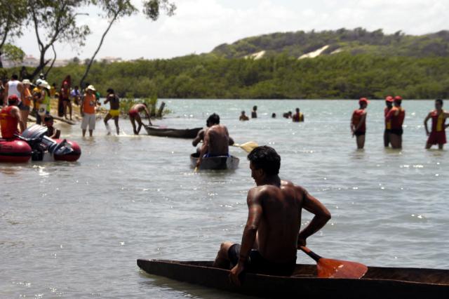 Índios em canoas a beira rio