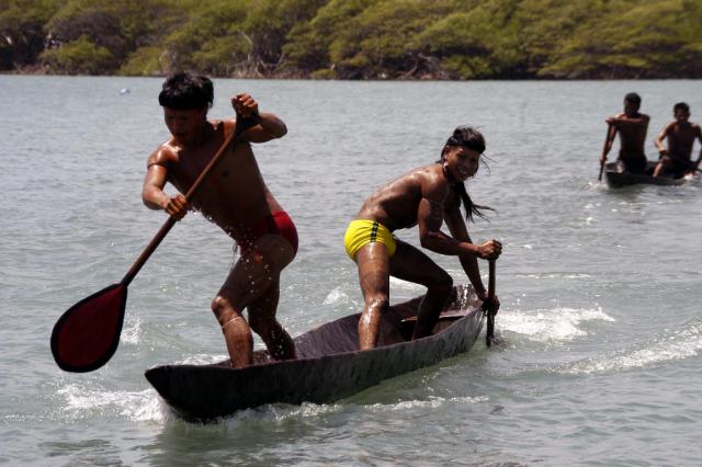 Índios remando em competição de canoagem