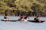 índios remando em competição de canoagem