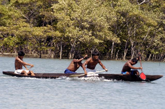 índios remando em competição de canoagem