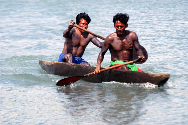 índios remando em competição de canoagem