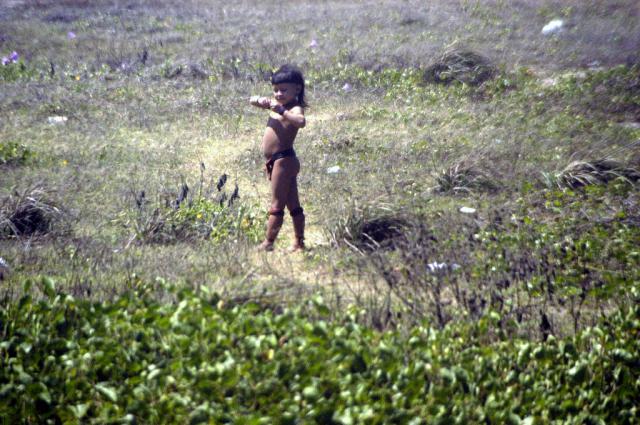 criança indígena entre a vegetação