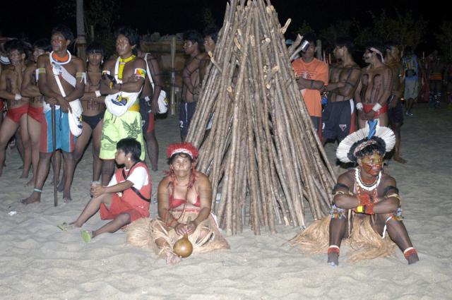 índios sentados em frente à pira