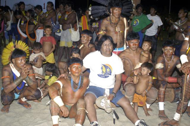 Marcos Terena sentado com índios na arena