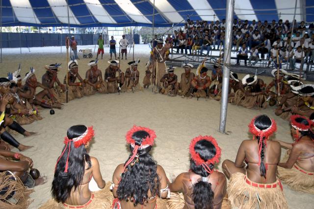 Índios em círculo no centro da tenda